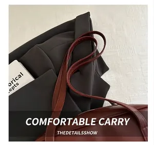 Detail shot of the comfortable double handles on a vintage brown leather Boston bag