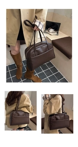 Macro detail of dark brown PU leather tote bag with smooth texture and sturdy shoulder straps