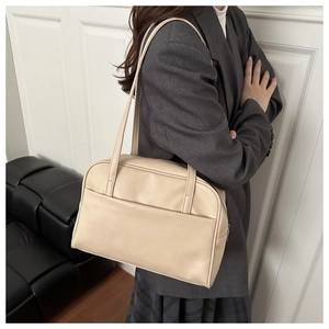 Detail of minimalist beige tote bag with shoulder straps and front pocket for workwear