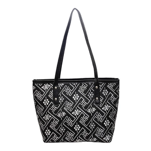 Minimalist black tote bag with white geometric embroidery and leather shoulder straps