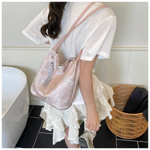 Close-up of pink jacquard tote bag featuring floral embroidery and silver fringe tassel