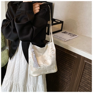 Detail of Chinese style floral embroidery on off-white satin bag with long tassel charm