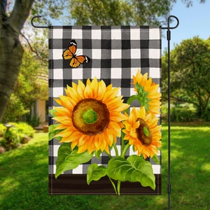 Detail of garden flag with buffalo check pattern, sunflowers and a butterfly in garden