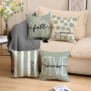 Set of 4 sage green autumn pumpkin pillow covers with festive harvest typography on sofa