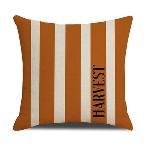 Detail of harvest pumpkin pillow cover featuring orange stripes and harvest typography