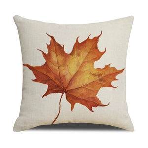 Detail of a square linen pillowcase featuring a realistic orange maple leaf print