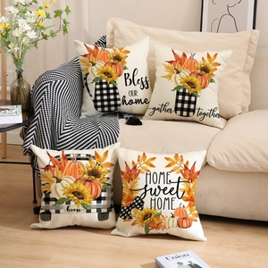 Set of four autumn-themed throw pillow covers featuring pumpkins and sunflowers on a couch