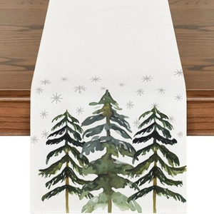 White linen Christmas table runner featuring green trees and grey snowflakes on wood