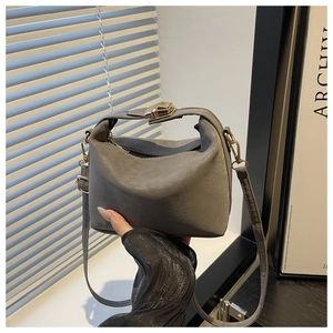 Detail of grey mini shoulder bag with gold metal buckle and adjustable strap