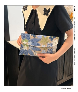 Detail of floral embroidery and silver sequins on elegant handmade envelope clutch bag