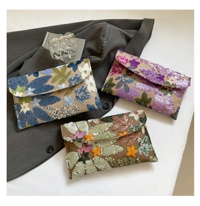 Detailed close-up of handmade envelope clutches with sequin floral embroidery