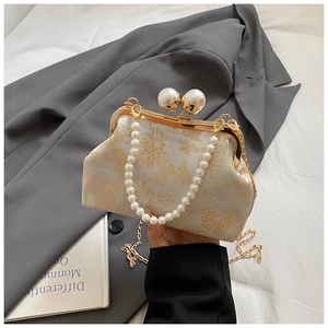 Macro detail of Chinese embroidery and pearl clasp on a vintage evening clutch bag