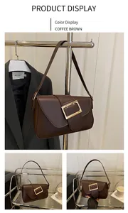 Detail view of coffee brown faux leather baguette bag with golden buckle closure