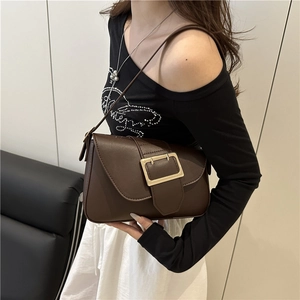 Deep brown faux leather baguette bag with large gold buckle shown on a female model