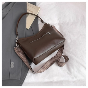 Détail du sac hobo avec une large bandoulière tissée géométrique et boucle en métal