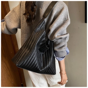Detail view of the black woven texture and large capacity design of the Hobo shoulder bag