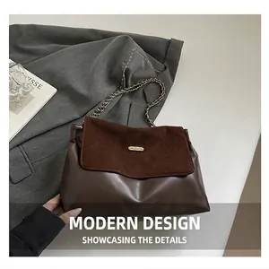 Detail of vintage brown shoulder bag with suede texture, gold chain and metal hardware
