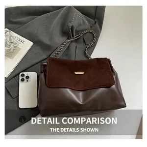 Detail of dark brown suede patchwork tote with golden chain and metallic buckle