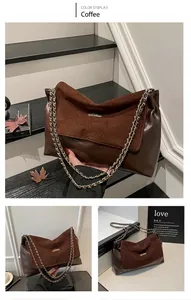 Detail view of coffee suede and faux leather shoulder bag with gold metal chain strap