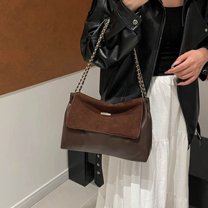 Retro large capacity tote bag in brown leather with chain strap worn by a model