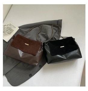 Detailed close-up of retro chain tote bags in dark brown and black leather with metal trim