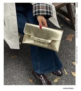 Detail der gold metallic plissierten Clutch mit rechteckigem Griff für modische Ausflüge