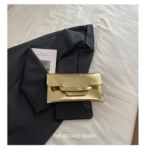 Goldene Umschlag-Clutch mit Knitteroptik, präsentiert neben einem Smartphone