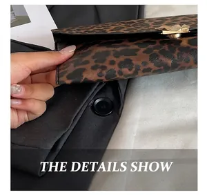 Detail view of leopard print clutch showing fine stitching and golden wavy metal buckle