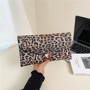 Dettaglio macro della pochette leopardata con fibbia metallica dorata lucida