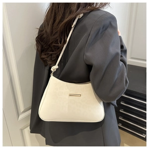 Gros plan sur la texture léopard beige et la bandoulière nouée d'un sac minimaliste