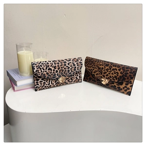 Detail of leopard print envelope clutches with stylish gold heart-shaped metal buckles