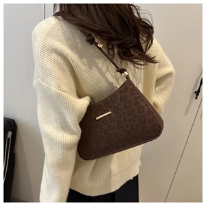 Détail du sac croissant à motif léopard avec boucle dorée et bandoulière à nœud