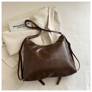 Detail of vintage dark brown tote bag showing supple leather texture and adjustable strap