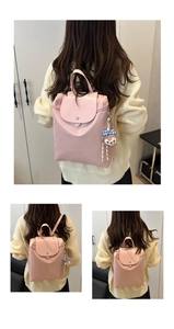Dettaglio dello zaino rosa con patta magnetica e ciondolo a forma di orsetto di peluche
