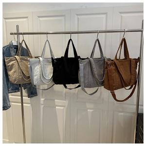 Detail of corduroy tote bags in five colors on a rack with adjustable straps