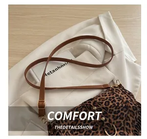 Détail du sac besace à imprimé léopard avec ferrures dorées et bandoulière brune