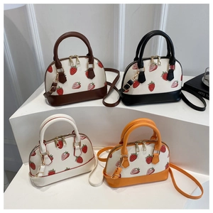 Multiple colors of strawberry print mini shell bags with gold hardware and shoulder straps