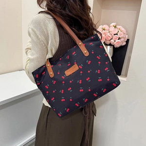Minimalist black tote bag with cherry print and brown leather handles for women