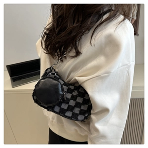Dettaglio borsa a tracolla in tweed a scacchi con catena d'argento e mini astuccio