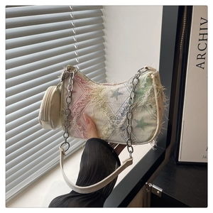 Detail of hobo bag with star prints, fringe edges, silver chain, and matching coin purse