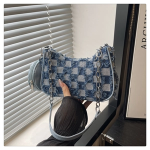Detailed shot of checkered denim baguette bag with fringe edges and chain strap