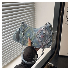 Detail of vintage denim shoulder bag featuring star patterns and long fringe accents