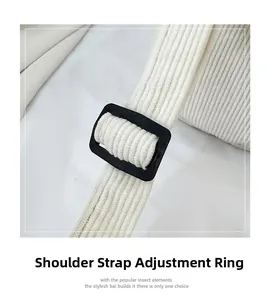Detail view of the white corduroy shoulder strap with a black plastic adjustable buckle