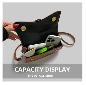 Internal capacity of the brown leather crossbody bag showing daily essentials inside