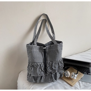 Dettaglio della borsa tote a quadretti con eleganti balze sul fondo e coulisse
