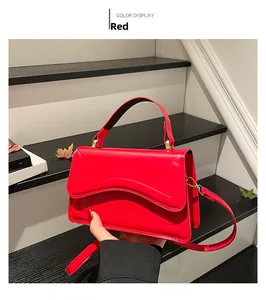 Détails du sac à main rouge avec coutures ondulées et garnitures dorées élégantes