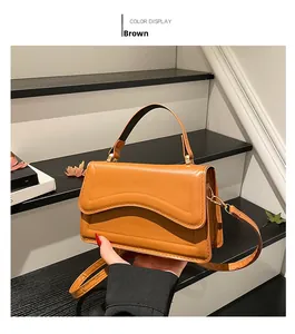 Détail du sac bandoulière marron avec rabat à vagues et fermoir métallique élégant