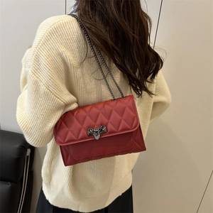 Sac bandoulière rouge matelassé avec fermoir métallique triangulaire et chaîne
