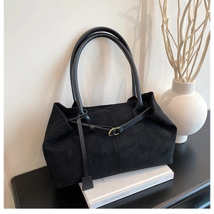 Detail view of the black frosted leather texture and side strap on the large tote bag