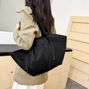 Black matte leather wing tote bag with high-capacity design shown on a female model